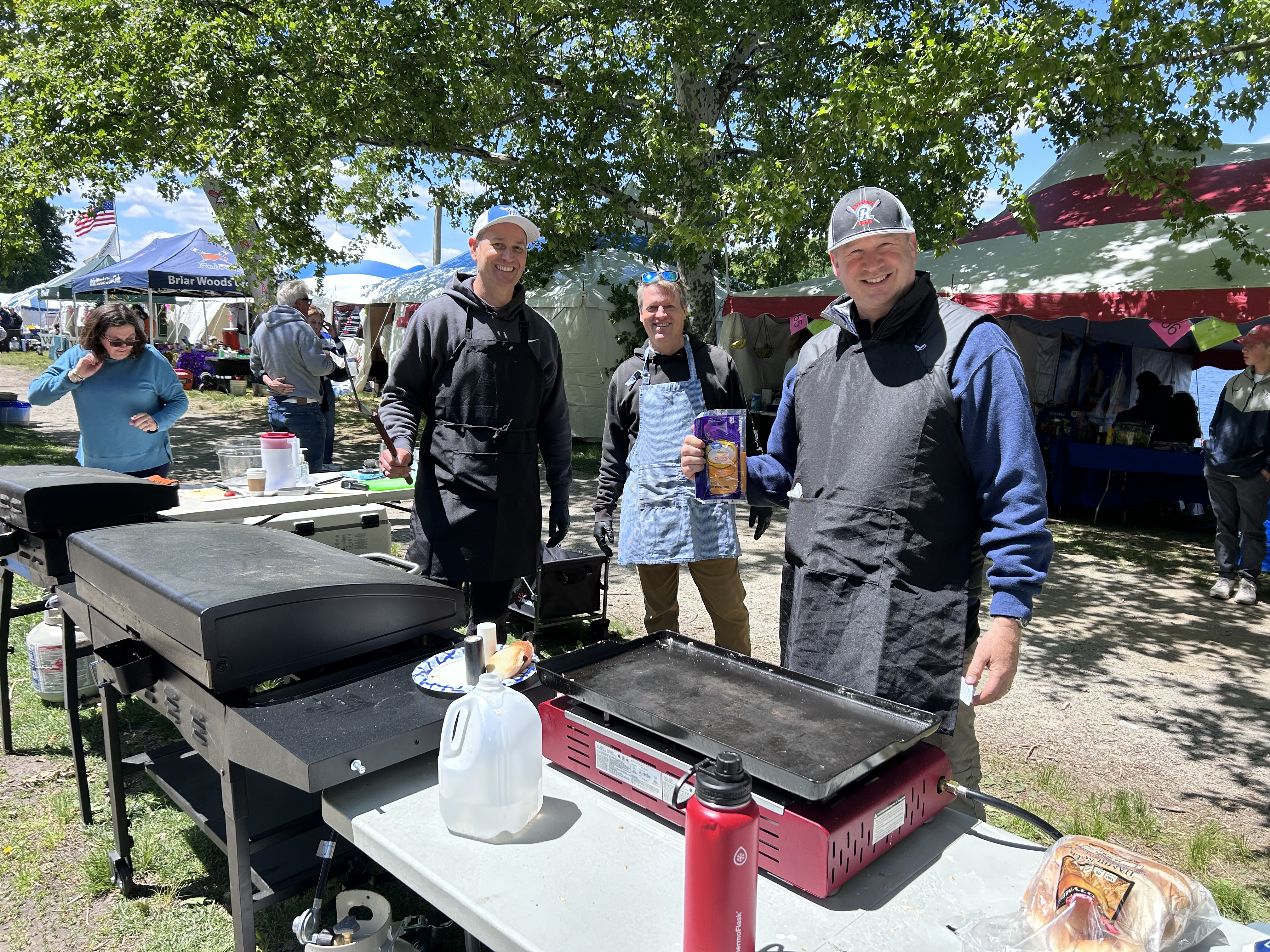 Riverside volunteers preparing food on griddles at a regatta